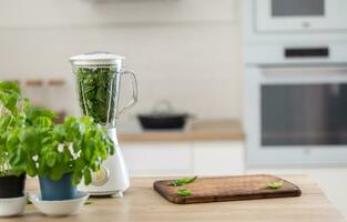 Küche mit frisch Kräuter, Grün Blätter Innerhalb das Bledner und ein Hacken Tafel foto