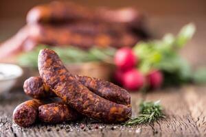 Würste. geräuchert Würste. Chorizo Würste mit Gemüse Rosmarin Gewürze und Küche Utensil. foto