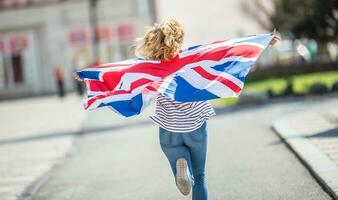 attraktiv glücklich jung Mädchen mit das Flagge von das großartig Großbritannien foto