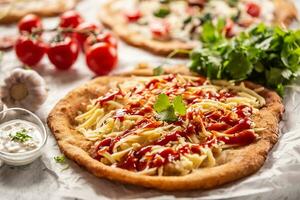 käsig ungarisch traditionell gebacken Langos mit Ketchup, Knoblauch und Kräuter serviert auf ein Backen Papier mit Tomaten und Gemüse und sauer Sahne foto