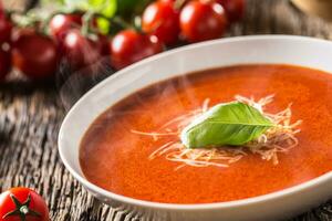 heiß Tomate Suppe Parmesan Käse und Basilikum verlassen auf alt öl Tabelle foto