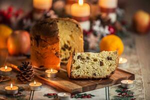 köstlich Panettone auf Weihnachten Tabelle Witz Dekorationen und Advent Kranz und Kerzen foto