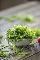 frisch Rucola Salat im Weiß Gericht auf hölzern Tabelle foto