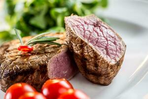 Rindfleisch Steak. saftig Rindfleisch Steak. Gourmet Steak mit Gemüse und Glas von Rose Wein auf hölzern Tabelle foto