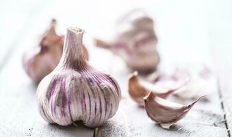 Knoblauch Nelken und Glühbirnen auf Jahrgang hölzern Tabelle foto