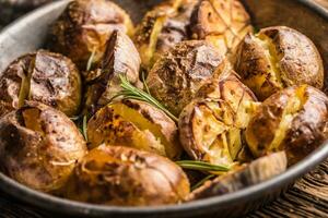 Kartoffeln geröstet mit Knoblauch Gewürze und Kräuter im Jahrgang schwenken foto