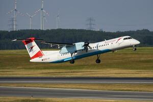 österreichisch Fluggesellschaften Bombenschütze dhc-8 q400 oe-lgj Passagier Flugzeug Abfahrt und nehmen aus beim Wien Flughafen foto