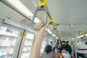 Frau Hand Feste Griff Sicherheit Geländer im erhöht Einschienenbahn Zug. Masse Transit System im modern Stadt. Innerhalb von elektrisch Zug. Tourist Reise durch Stadt Himmel Zug. Öffentlichkeit Transport. städtisch Transport. foto