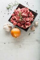 Rindfleisch. roh geschnitten Rindfleisch Fleisch Knoblauch Zwiebel Salz- Pfeffer und Rosmarin foto