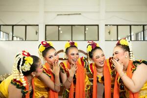 ein Gruppe von traditionell javanisch Tänzer Lachen zusammen mit lächerlich Gesichter und voll von Freude während auf Bühne foto