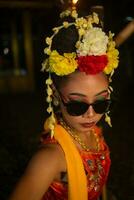 ein javanisch Tänzer Tänze sehr geschickt während tragen Sonnenbrille auf ihr Augen und sehr schön Gesichts- bilden foto