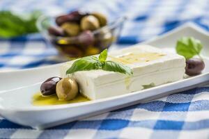 griechisch Käse Feta mit Olive Öl Oliven und Basilikum Blätter foto