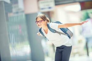 Schülerin mit Tasche, Rucksack. Porträt von modern glücklich Teen Schule Mädchen mit Tasche Rucksack. Mädchen mit Dental Hosenträger und Brille foto