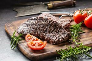 zwei Rindfleisch Rumpf Steaks mit Kräuter Tomaten Salz- und Gewürze auf Metzger Tafel foto