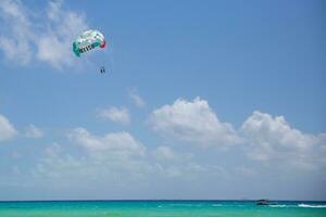 türkis Meer und ein Parasailing Fallschirm mit Zeichen Mexiko und Farben von das Flagge von diese Land über das Karibik Meer foto