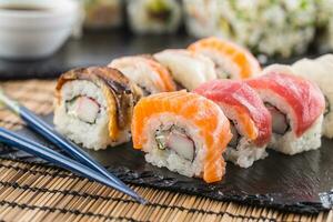 einstellen von rollen Sushi Gold Kalifornien mit Essstäbchen und Soja Soße. foto