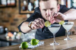 Barmann im Kneipe oder Restaurant vorbereiten ein Cocktail trinken Margarita. foto