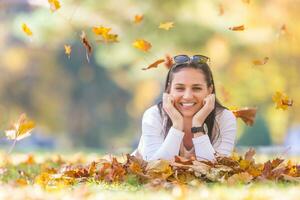 Glück Frau Sitzung im Herbst Park halten Strauß mit fallen Blätter foto