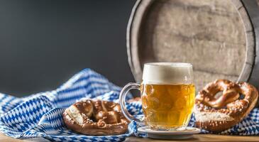 Oktoberfest Bier mit Brezel hölzern Fass und Blau Tischdecke foto