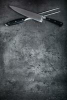 Gabel und Messer. Gabel und Messer gekreuzt auf Beton Tafel foto