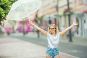 schön jung blond Mädchen halten Regenschirm im Sommer- Regen foto