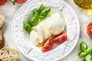 Mozzarella Käse Tomaten Basilikum und Olive Öl. Caprese Salat - - Italienisch oder Mittelmeer Mahlzeit oder Vorspeise foto