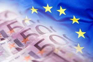 bunt winken europäisch Union Flagge auf ein Euro Geld Hintergrund foto