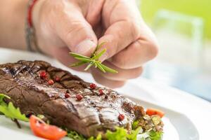 Koch bereit Rindfleisch Flanke Steak mit Gemüse Dekoration. foto