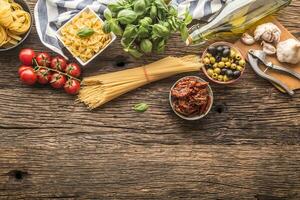 Italienisch Essen Zutaten Pasta Olive Öl Parmesan Käse Basilikum Knoblauch Pilze Tomaten Oliven auf hölzern Tabelle foto