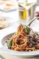 Spaghetti mit Pomodoro Soße, Basilikum und Parmesan Käse gegessen durch ein Gabel foto