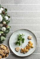 das von Aussicht auf ein Teller mit Lebkuchen mit melissa Kräuter auf das Tabelle LED ein Advent Kranz foto