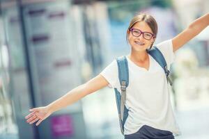 Schülerin mit Tasche, Rucksack. Porträt von modern glücklich Teen Schule Mädchen mit Tasche Rucksack. Mädchen mit Dental Hosenträger und Brille foto