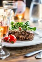 Rindfleisch Steak. saftig Rindfleisch Steak. Gourmet Steak mit Gemüse und Glas von Rose Wein auf hölzern Tabelle foto