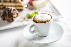 Tasse von Kaffee und Dessert auf Teller im Cafe Konditoren oder Restautant foto