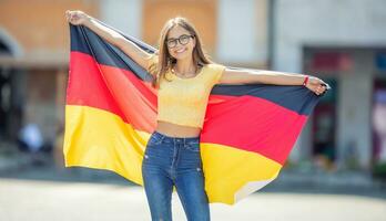 attraktiv glücklich jung Mädchen mit das Deutschland Flagge foto