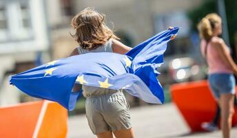 süß glücklich jung Mädchen mit das Flagge von das europäisch Union foto