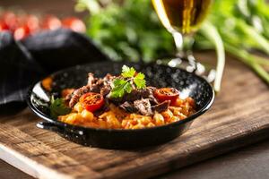 Tomate Soße Gnocchi mit Sous-Vide Rindfleisch und frisch Tomaten serviert im ein dunkel Teller foto