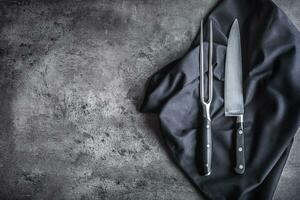 Gabel und Messer. Gabel und Messer schwarz Serviette Tischdecke auf Beton Tafel foto