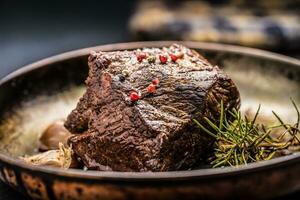 saftig Rindfleisch Steak mit Gewürze und Kräuter im alt schwenken foto