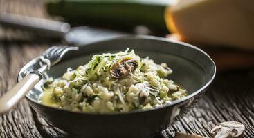 Italienisch Risotto Zucchini Pilze und Parmesan im dunkel Teller foto