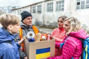 vysne Nemecke, Slowakei. März 30. 2022. männlich ngo Arbeiter gibt ein Box von Basic Essen und Toilettenartikel zu ein Familie von drei beim das Rand fliehen das Konflikt im Ukraine foto