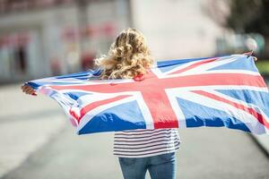 attraktiv glücklich jung Mädchen mit das Flagge von das großartig Großbritannien foto