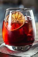 Negroni klassisch Cocktail und Gin kurz trinken mit Süss Wermut, rot bitter Likör und getrocknet Orange Garnierung foto