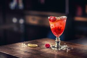 alkoholisch Getränk mit Himbeeren Zitrone und Eis auf Bar Zähler im Kneipe oder Restaurant foto