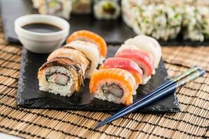 einstellen von rollen Sushi Gold Kalifornien mit Essstäbchen und Soja Soße. foto