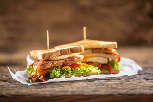 Verein Sandwich auf ein rustikal Tabelle Hexe Huhn, Speck, Pfeffer und Grüner Salat. foto