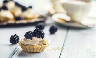 Mini Törtchen mit Brombeeren ausgepeitscht Sahne und Kaffee. foto