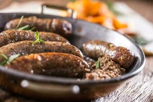 Würstchen.gebraten Schweinefleisch Würstchen im ein schwenken mit Kartoffeln und Rosmarin. foto