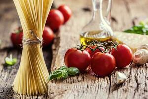 Spaghetti.Spaghetti Tomaten Basilikum Olive Öl Parmesan Käse und Pilze auf sehr alt Eiche Tafel. mediterran Küche und Zutaten foto