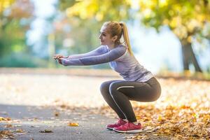weiblich sportlich jung Frau tun Dehnen oder Erwärmen das Körper und vorbereiten zu Joggen foto